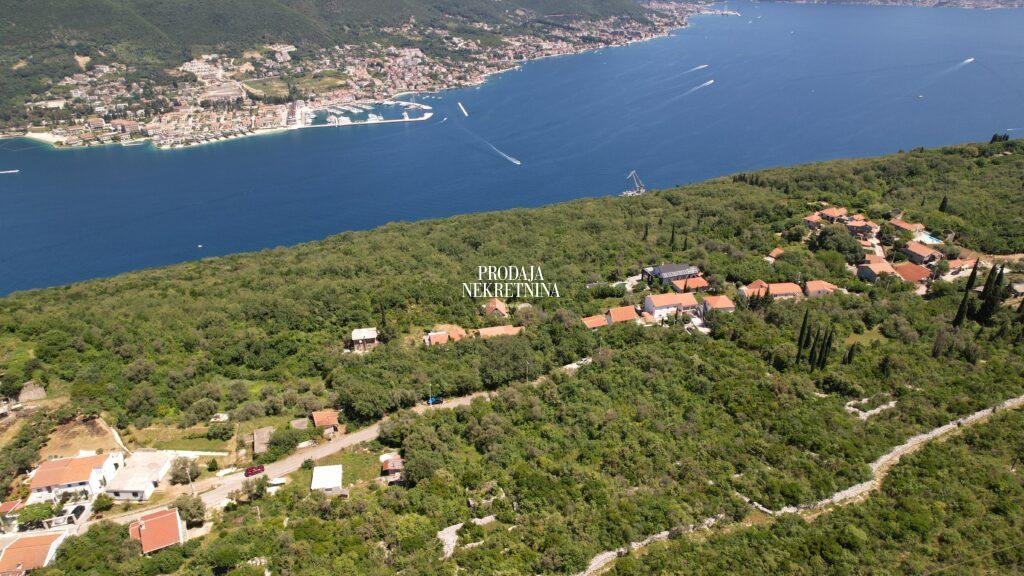 Drone footage of village zabrdje which is very little urbanised, with few houses and majority of untouched nature. there is sea in the front and across it, on the other shore there is porto novi luxury marina and village.
