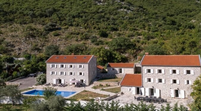 slika iz drona kooja prikazuje 3 kamene kuce od cega jedna ima bazen