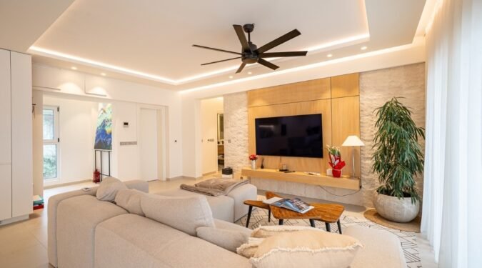 moderna i potpuno opremljena dnevna soba sa toplim neutralnim tonovima i velikom biljkom pored televizora